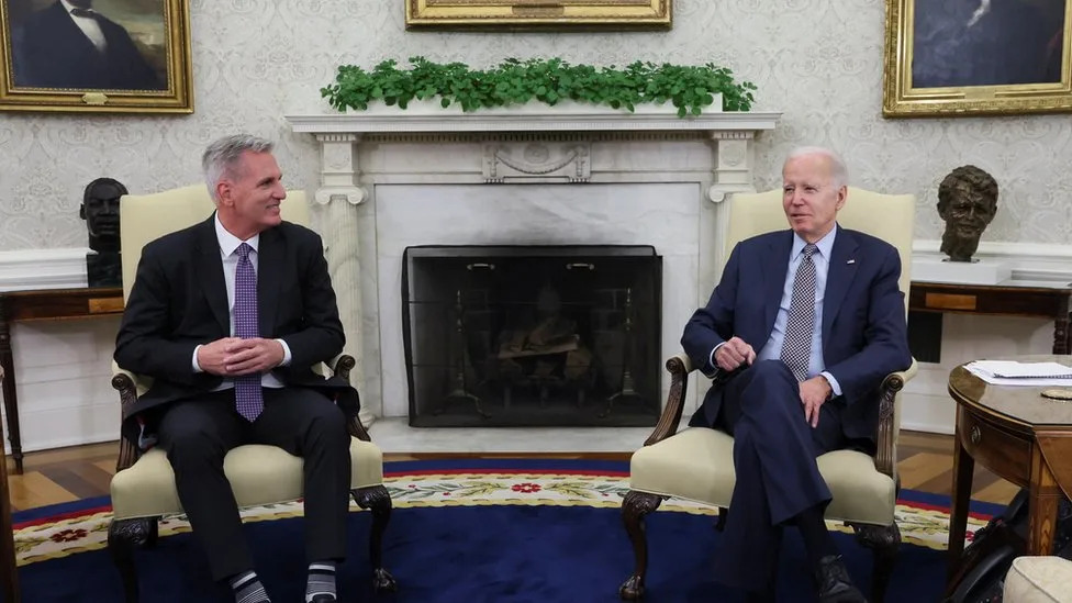 Photo of President Joe Biden and House Minority Leader Kevin McCarthy engaged in a discussion at the White House about the US debt ceiling crisis.