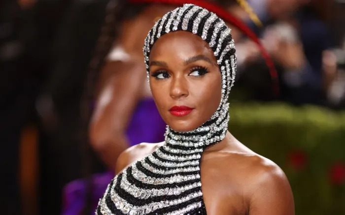 Janelle Monae wearing a black velvet dress with crystals and a starry headpiece at the 2022 Met Gala